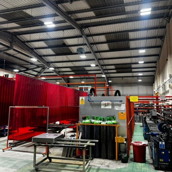 Plant room with commercial LED lighting installed above mechanical equipment and pipework