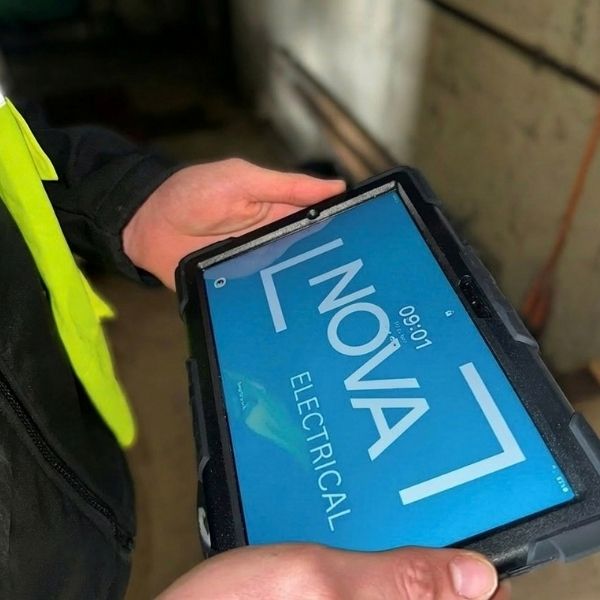 Nova Electrical engineer reviewing electrical inspection information on a tablet during an EICR visit