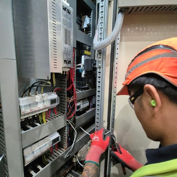 Planned Electrical Maintenance Engineer Nova Electrical engineer carrying out planned electrical maintenance on a commercial control panel